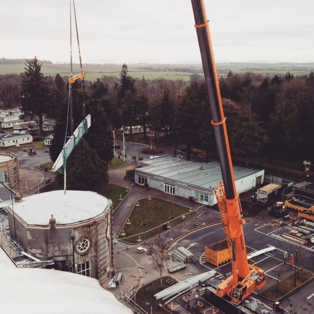 250te crane lifting a truss section beside the tower at Haggerston Castle