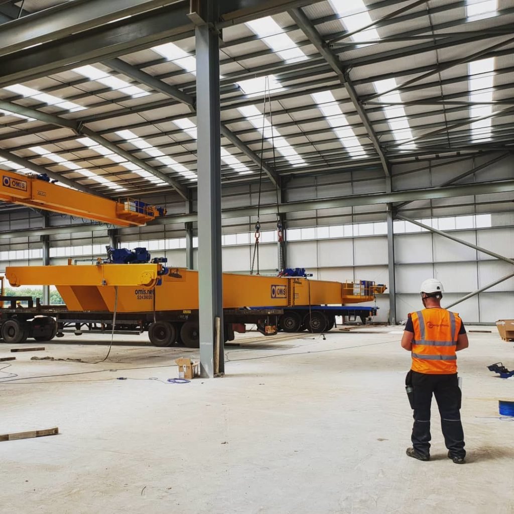 Overhead crane units built up on the warehouse floor ready to be lifted onto their tracks