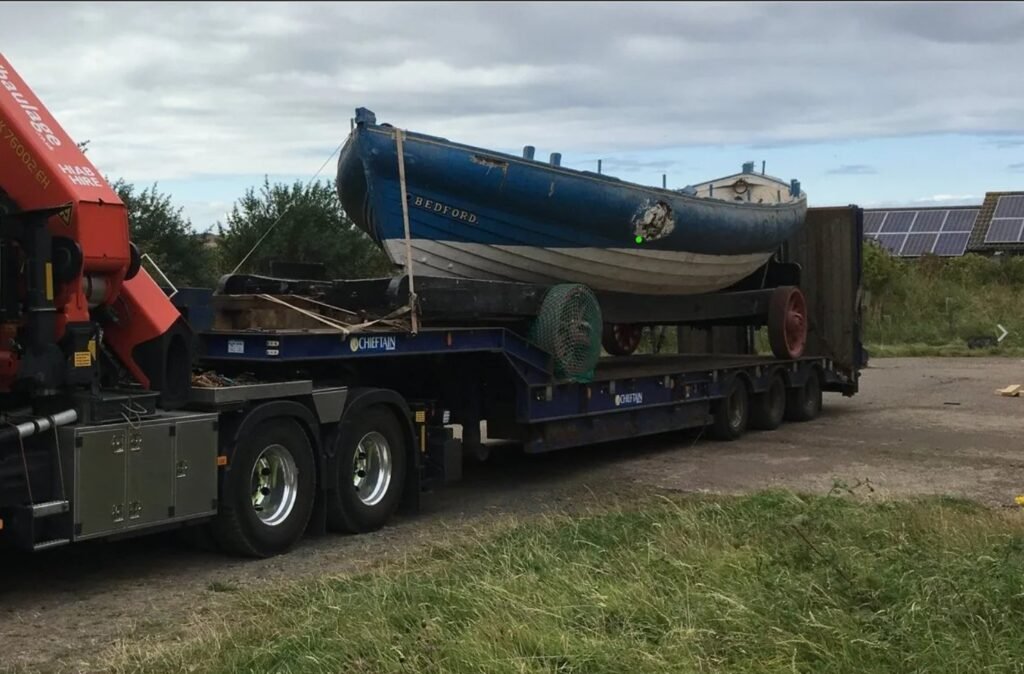 The restored Bedford loaded on a low loader for transport to storage