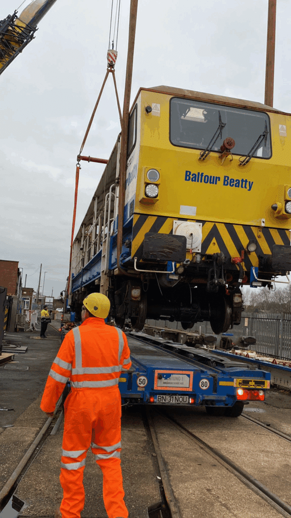 60te rail machine lowered onto a trailer in a tandem lift for export