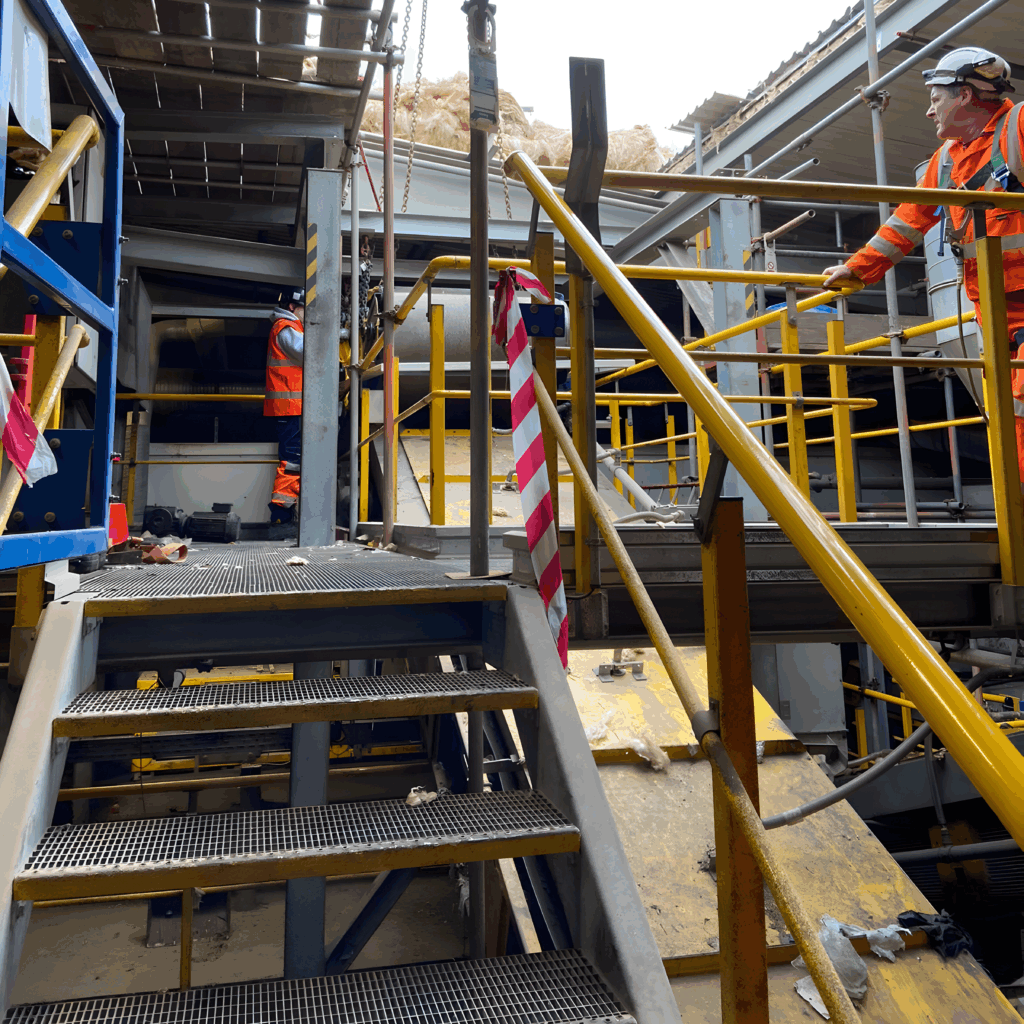 Crew preparing the magnetic belt conveyor for the lift inside the plant