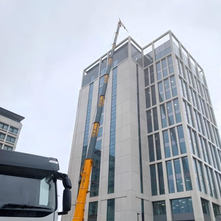 Mobile crane with fly jib rigged beside a 64m building in Newcastle