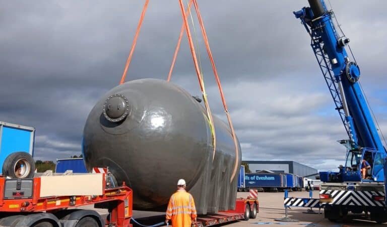 Sand filter vessel lifted onto a low loader at Pershore by a 60te all-terrain crane, with a rigger standing clear