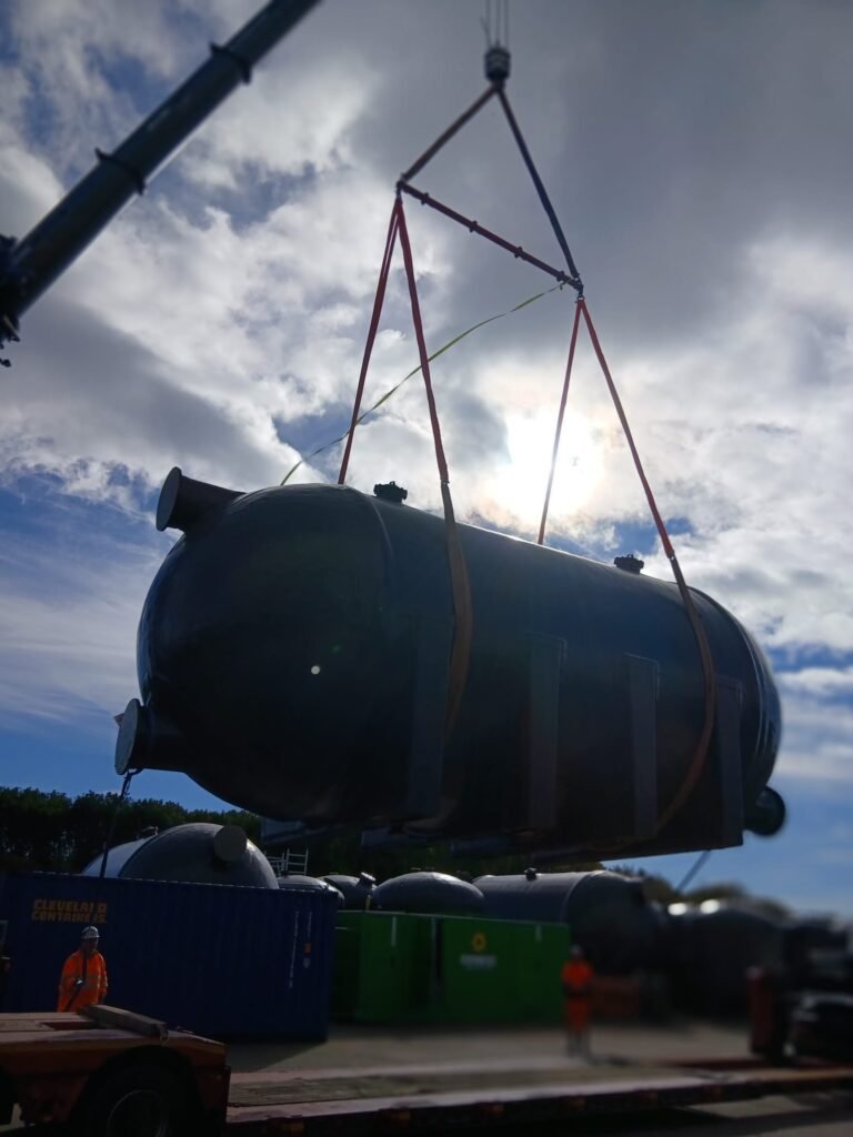 Sand filter vessel hanging level from a spreader beam with endless slings passed under it at the Pershore storage yard